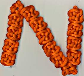 orange letter n tied with plafond and sauvastika knots